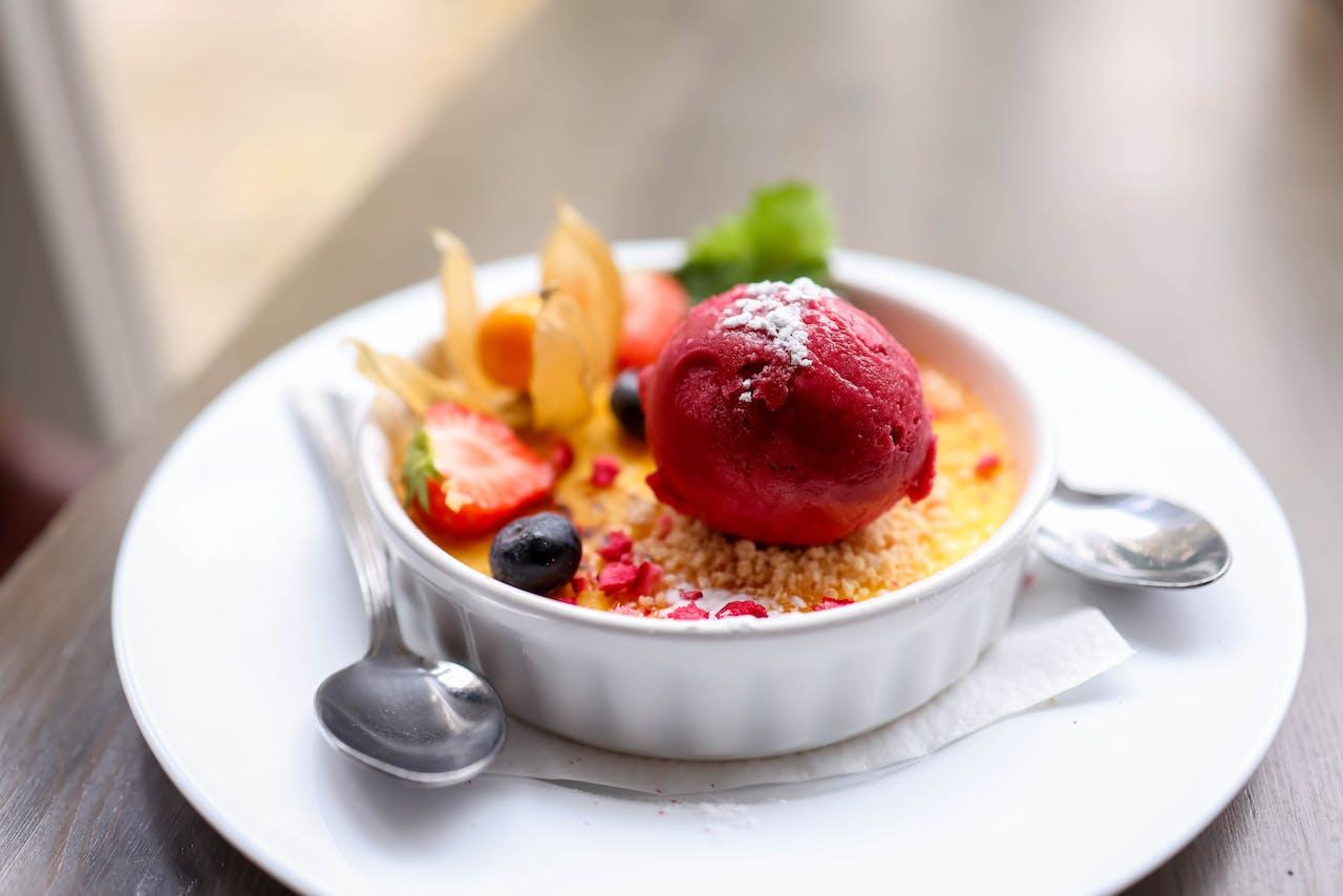Photo by Valeria Boltneva: https://www.pexels.com/photo/bowl-of-creme-brulee-with-strawberry-ice-cream-and-berries-18976997/